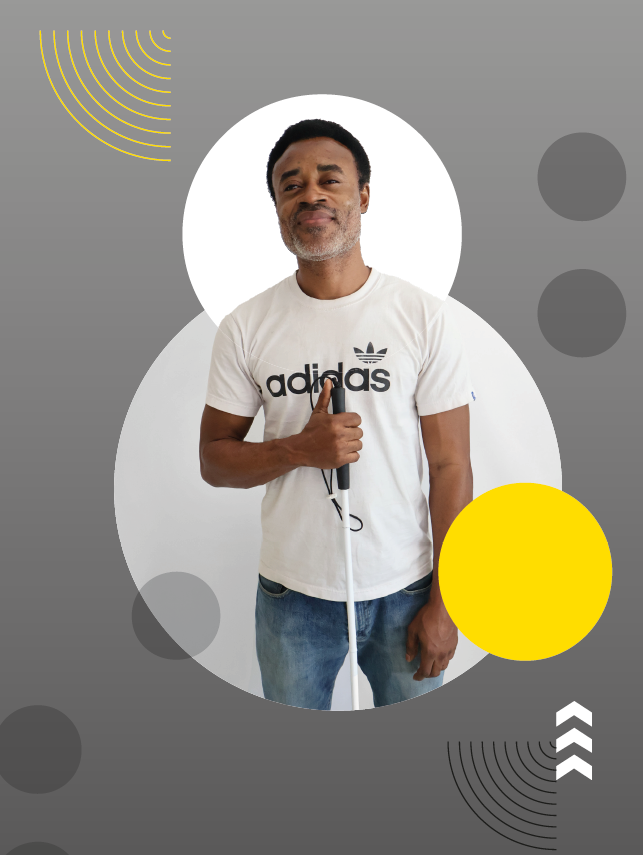 Imagem: Fotografia. Homem de cabelos pretos e curtos e barba grisalha curta usa camiseta branca com o texto adidas em preto e calça jeans azul, segura uma bengala branca com a mão direita. O fundo é cinza com círculos em branco e amarelo, pontos em braille, setas brancas e linhas curvadas em preto e amarelo. Fim da imagem.