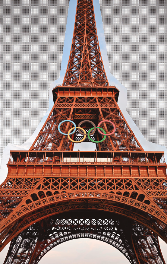 image: Photograph. The Eiffel Tower, a cone-shaped iron structure with three levels. In the center, the Olympic symbol, composed of five intersecting rings in blue, yellow, brown, green, and red. end of image.