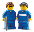 image: Photograph. Two toy building blocks, both wearing blue clothes, one of them holding a long cane. end of image.